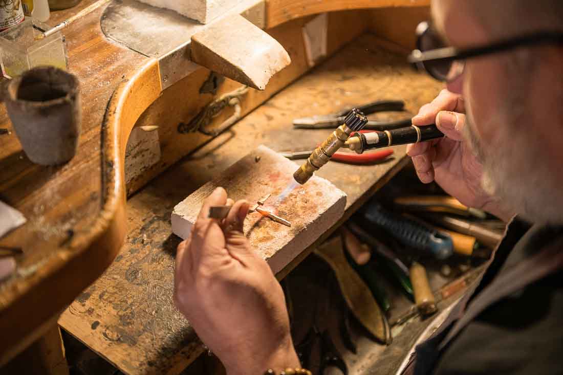 Manos de joyero trabajando en una pieza