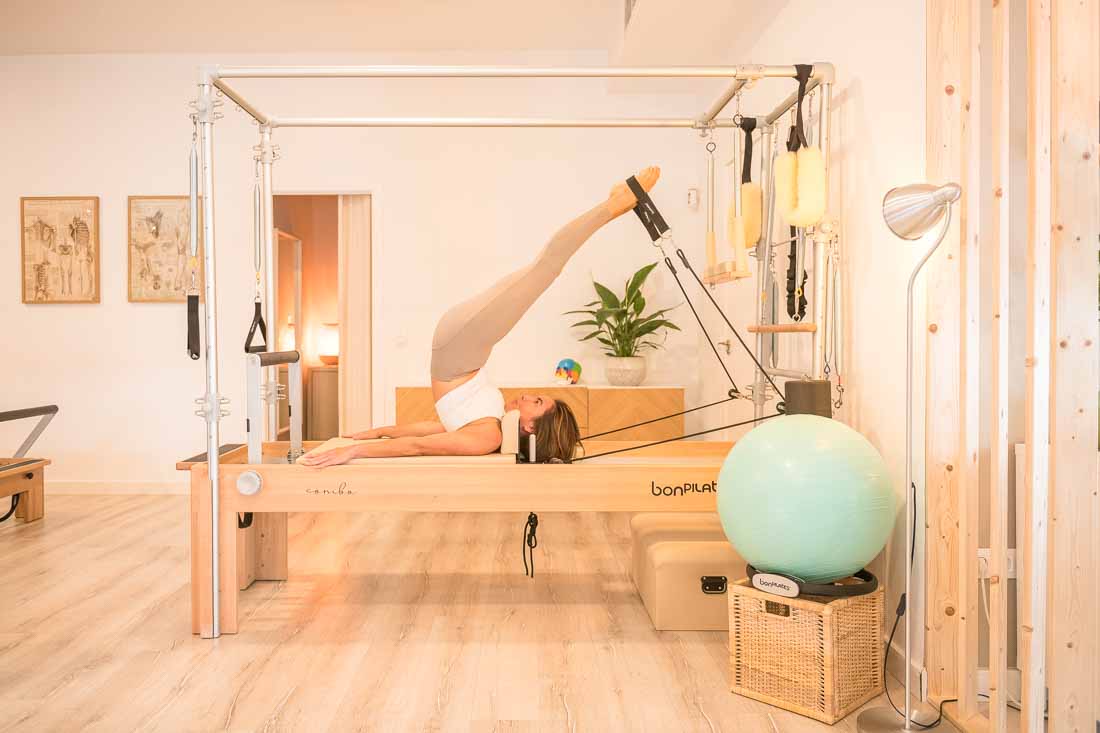 Profesora de pilates haciendo ejercicio sobre una máquina